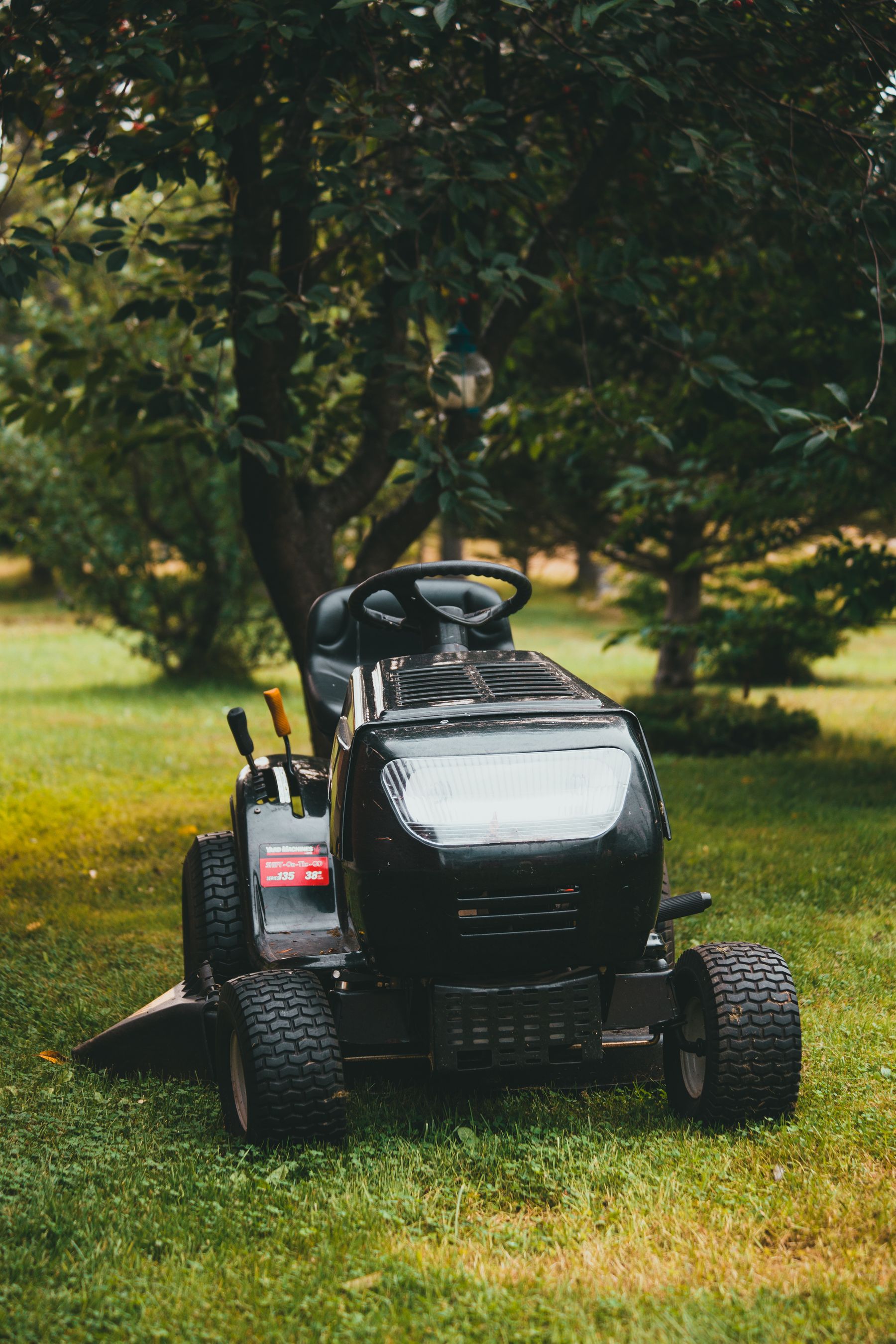 Licensed stock photograph of a riding mower on a green lawn